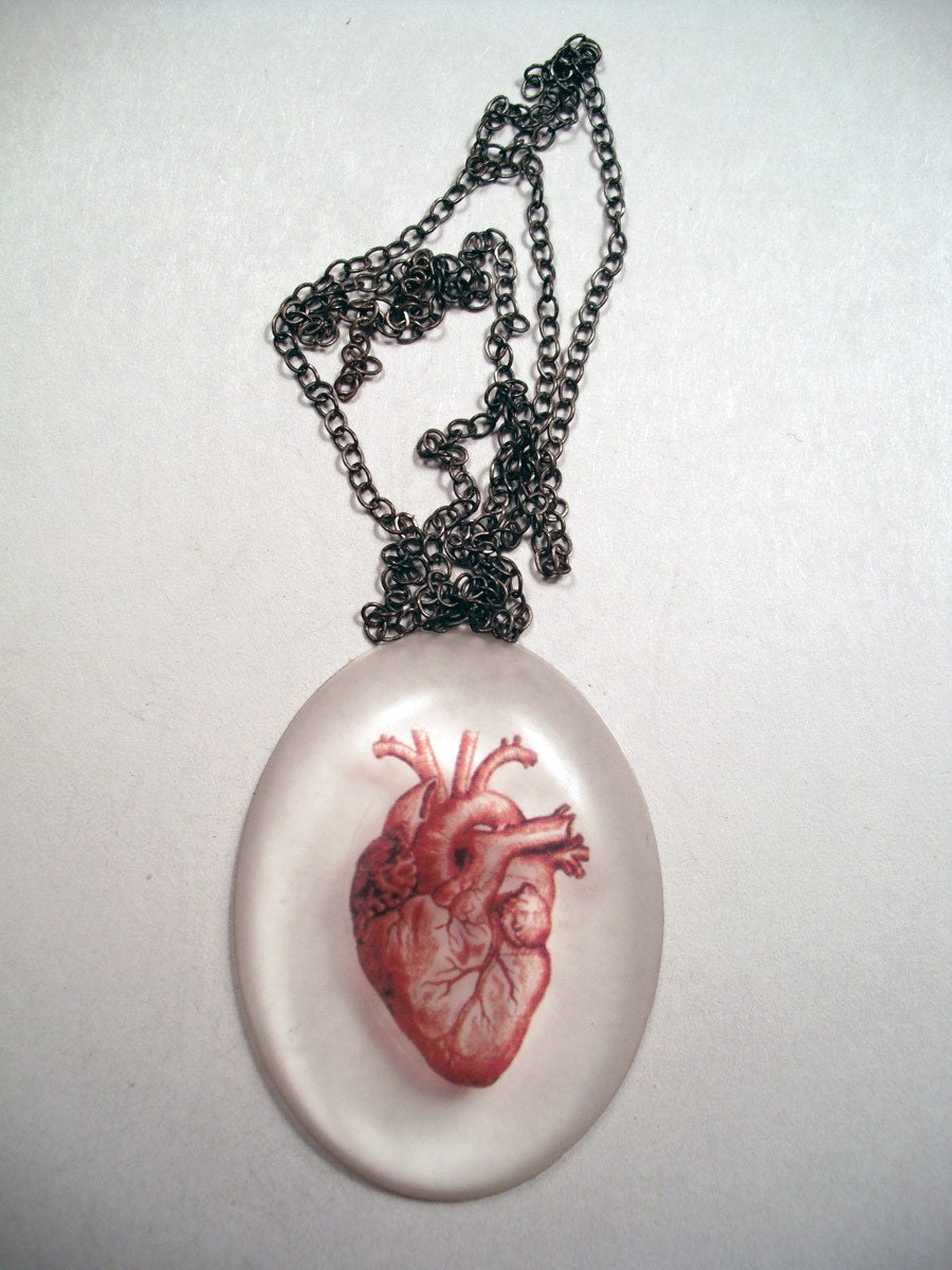 Clear oval pendant with red anatomical heart.