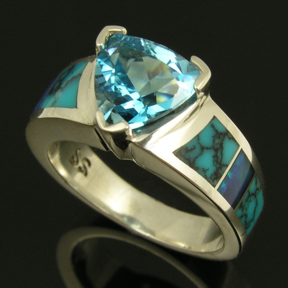 Sterling silver ring with a 225ct trillion cut blue topaz and inlaid with 