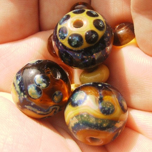 Honey Shimmer is a clear honey and opaque sandstone lampwork mini bead set with glittering oil slick dot and line decoration 
