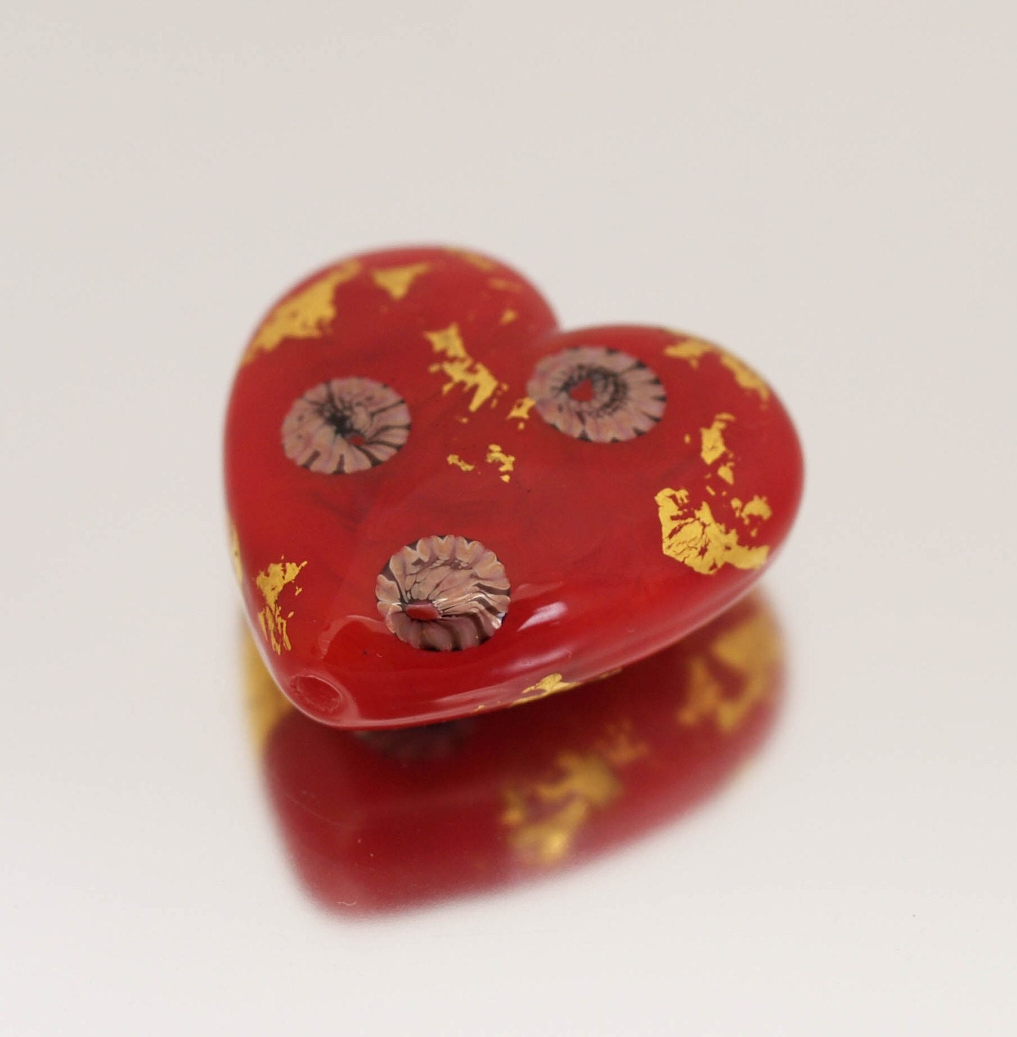 This lovely focal heart bead coordinates with the Geisha set. A stunning shade of scarlet red, decorated with white, red and black murrini and gold foil.