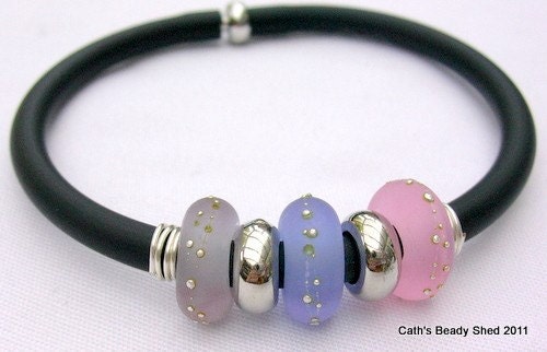 This is a PVC rubber tube bangle with 3 large lampwork glass beads and 2 silver plated spacers.