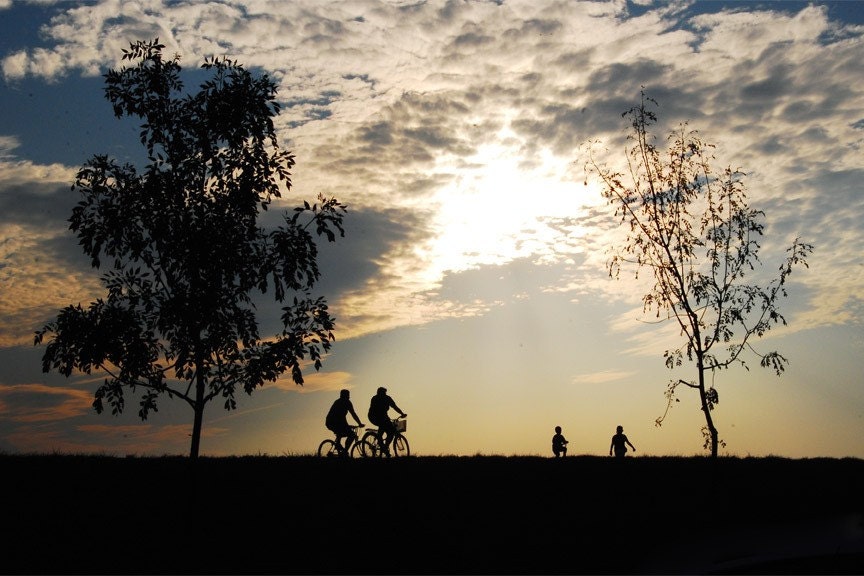 Two bicycle riders are silhouetted at Sunset in Zagreb, Croatia.
