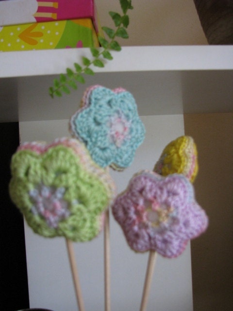 crocheted flowers in four joyful pastel colors - lilac, blue, green and yellow
